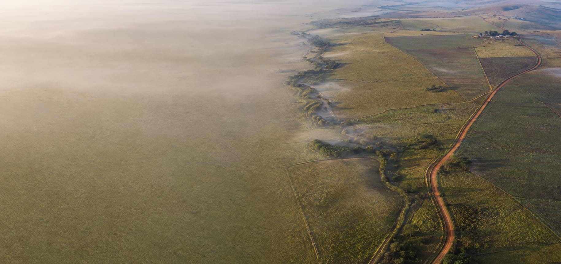 Propriedade rural vista de cima, com as divisas de cerca e a estrada de terra marcando os limites